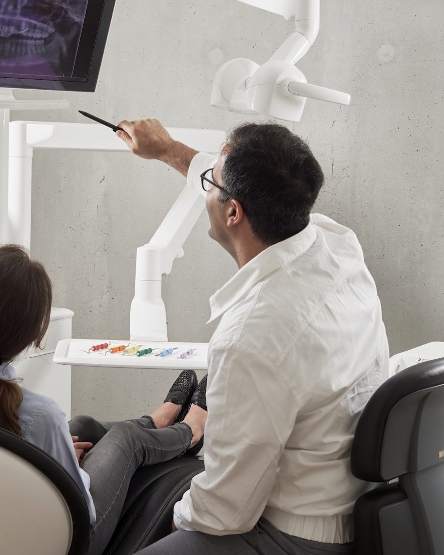 A dentist at work over a patient in the chair