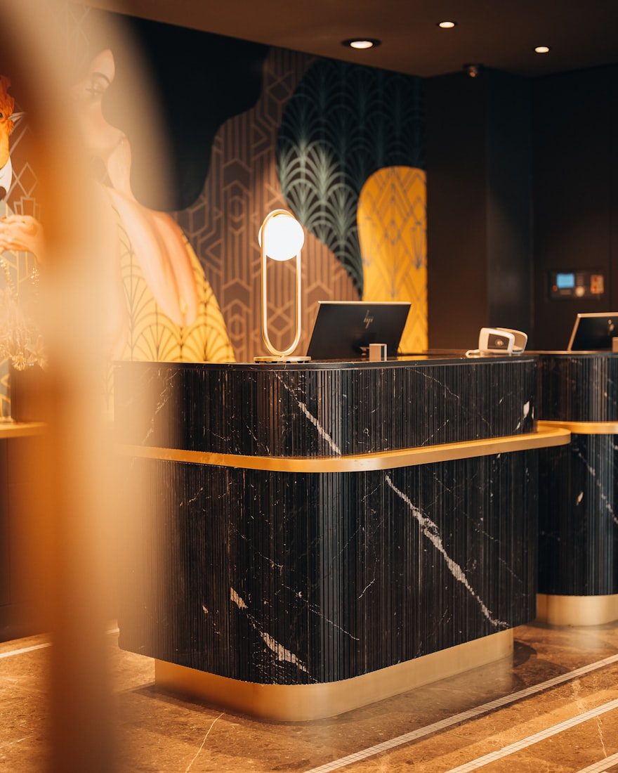 A dark marble reception desk with brass details