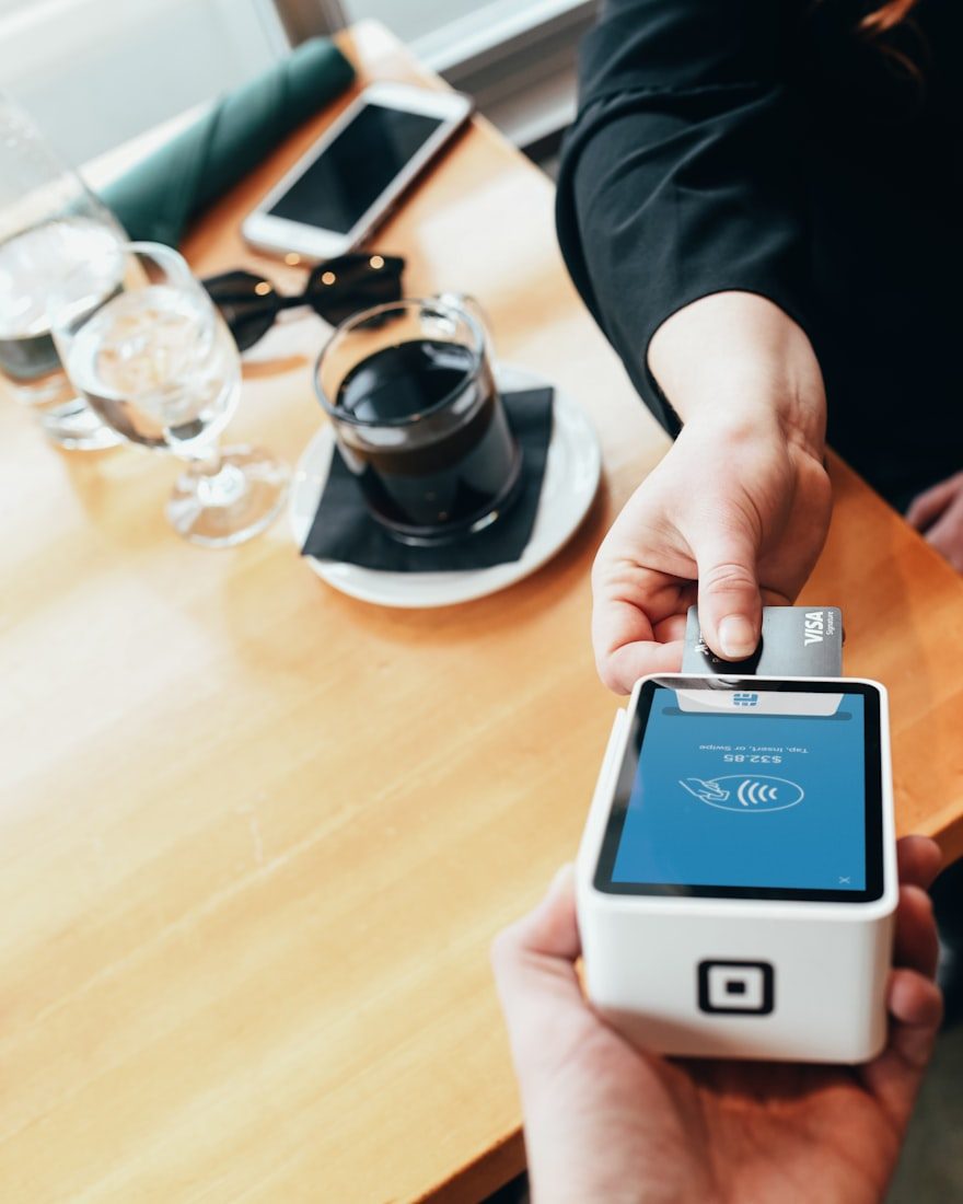 A hand holding a card reader at a counter